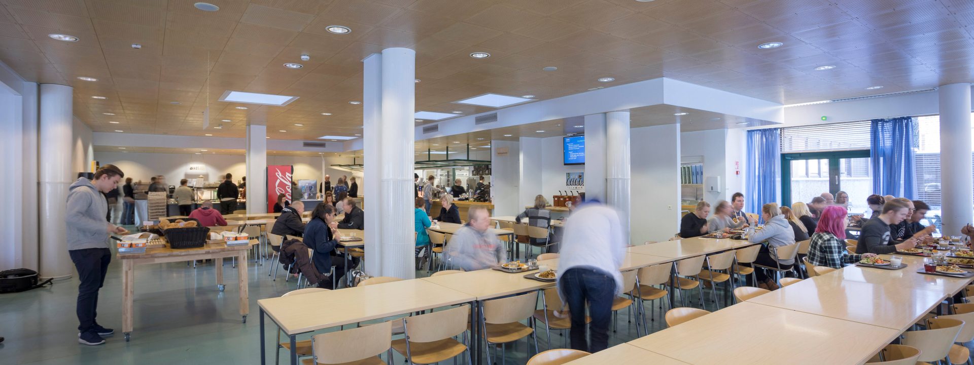 Yleiskuva ravinytolasta jossa näkyy pöytiä ja ihmisiä