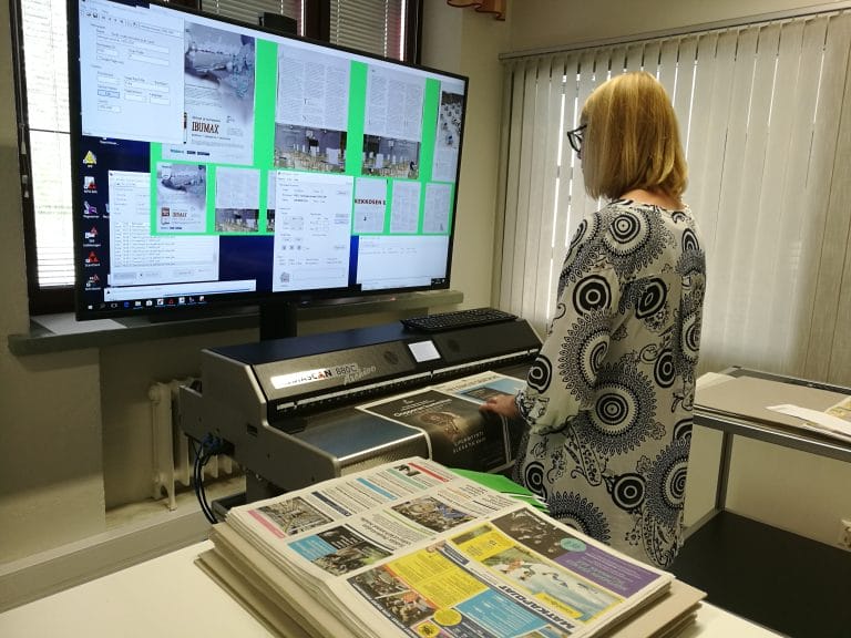 Kuvassa henkilö ison näyttöruudun ääressä digitoimassa aineistoja.