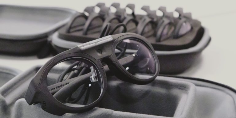 Puettava silmänliikekamera, taustalla linssisetti.