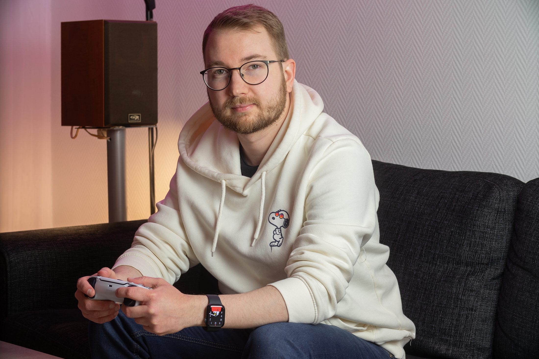 Mies istuu sohvalla peliohjais kädessään.