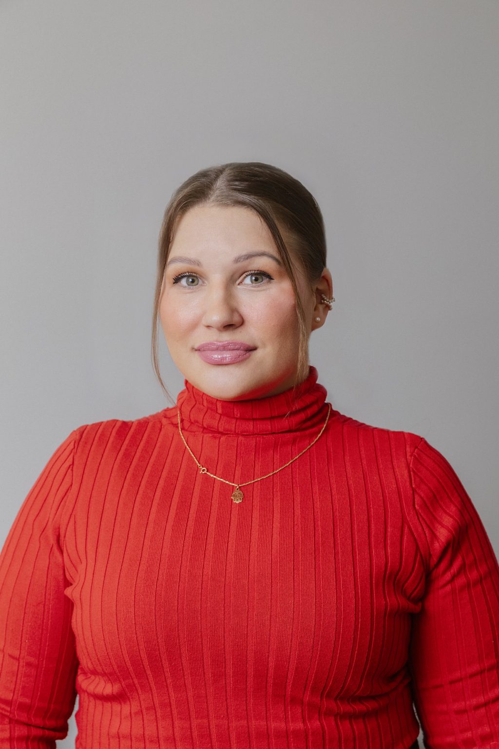 Henkilökuva. Ihminen katsoo kameraan ja hänellä on päällään punainen paita.