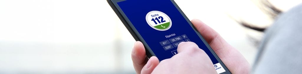 Puhelin, jossa on avattuna 112-sovellus, ja käsi näppäilemässä sitä.