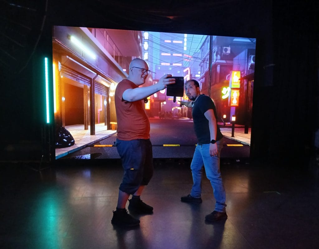 Meduusa-studion työntekijät testaavat selfien ottamista kuvausseinän edustalla.