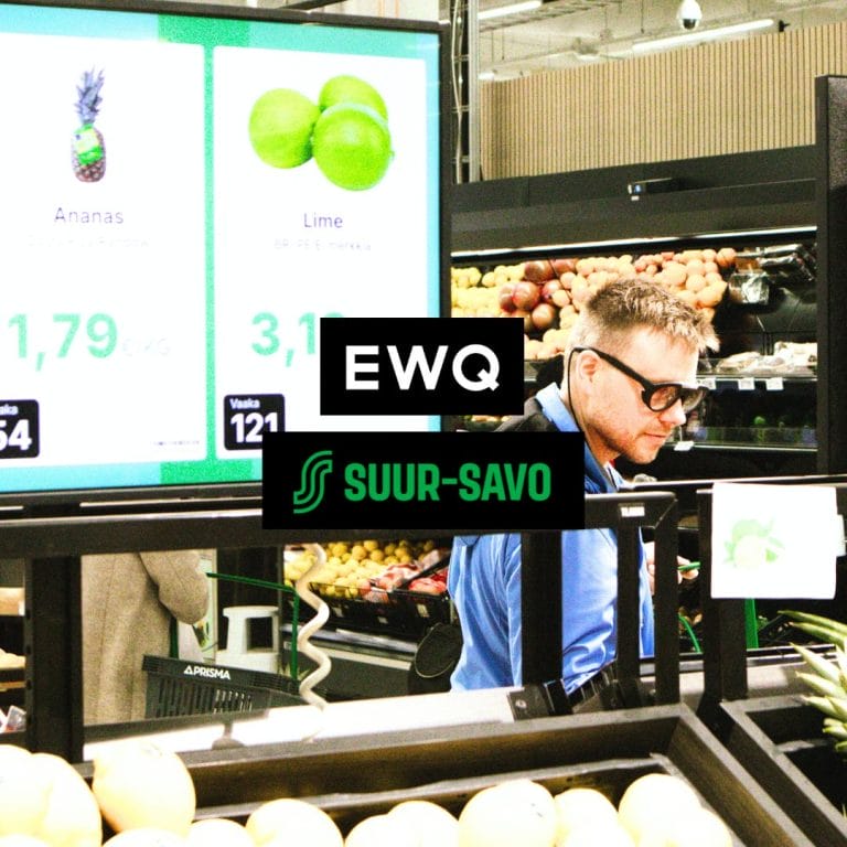 Mieshenkilö on ruokamarketissa hedelmä- ja vihannesosastolla, etualalla näkyy digitaalinen hintanäyttö.