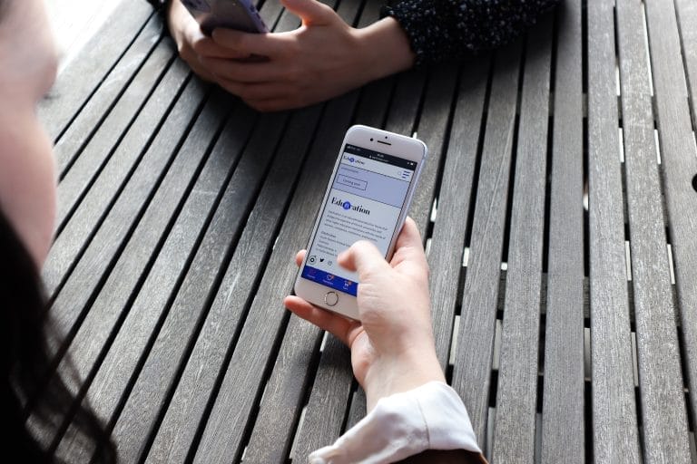 Henkilö käyttää digipalvelua mobiililaitteellaan.