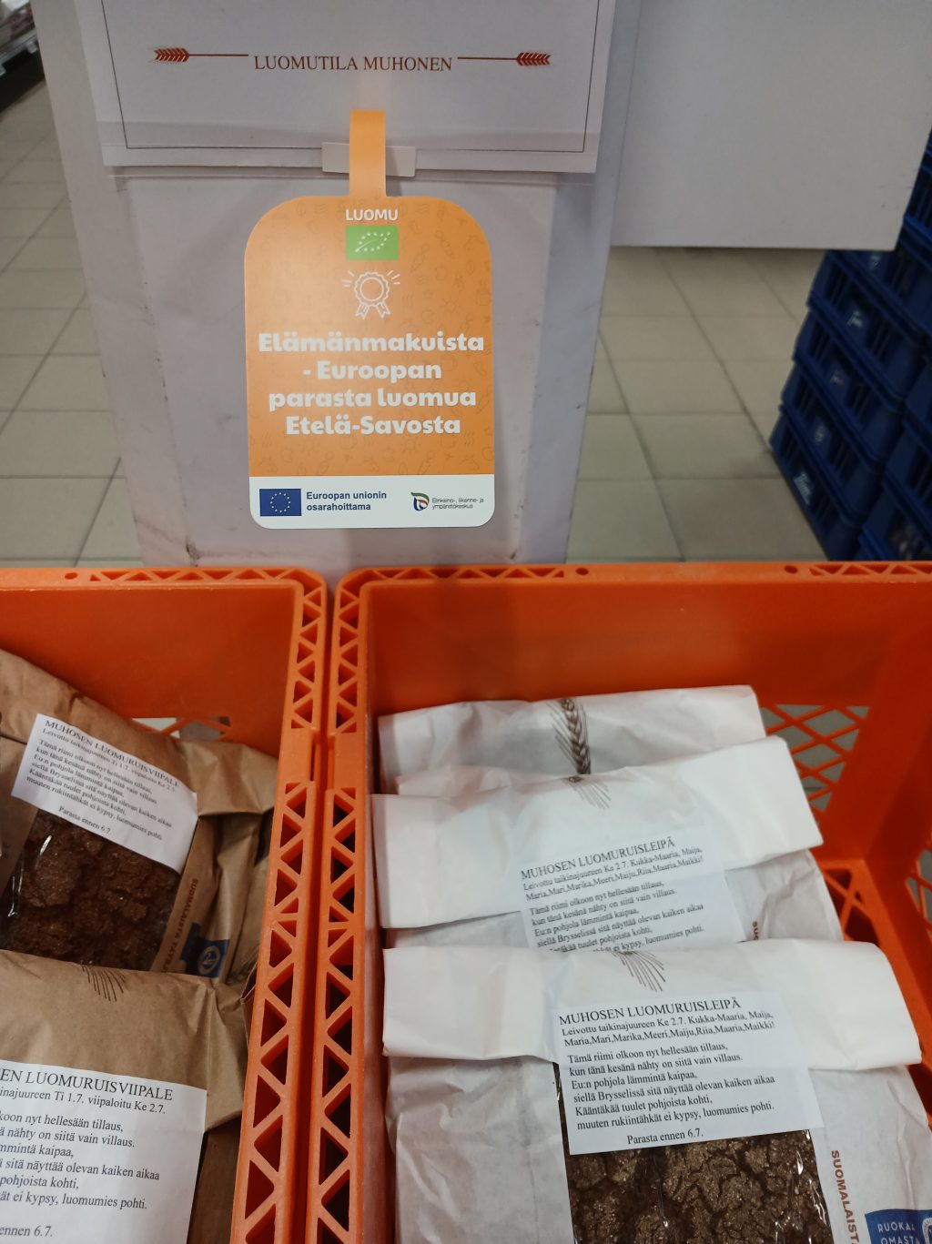 Infokyltti, jossa kerrotaan vieressä olevan leivän olevan paikallinen luomutuote.