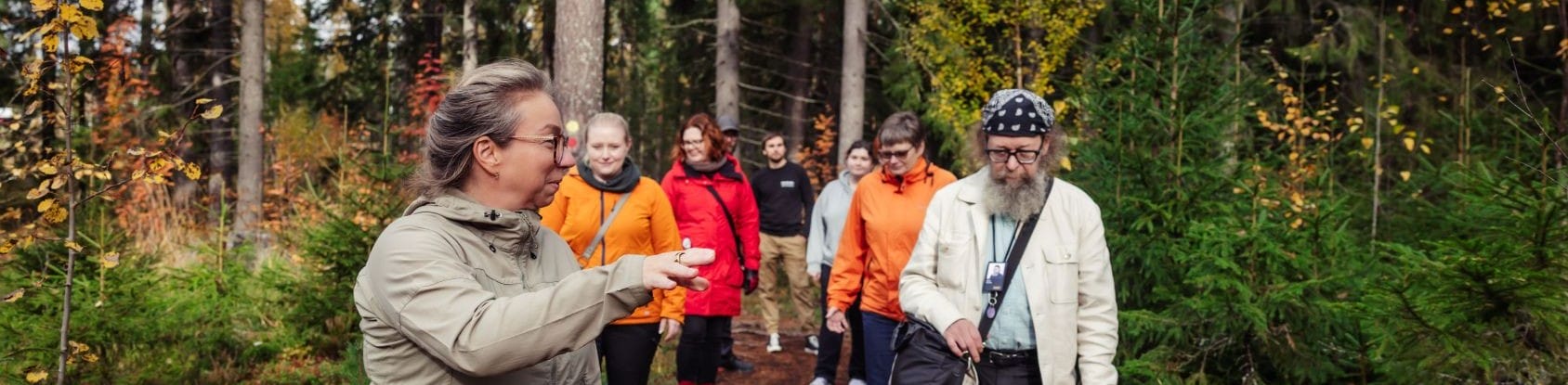 Ihmisiä kävelyllä metsässä.