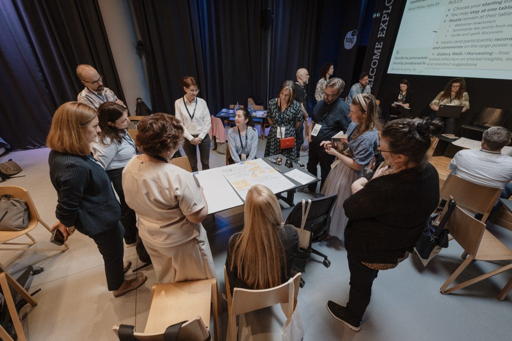 Kuvassa ihmisiä pöydän ympärillä miettimässä.