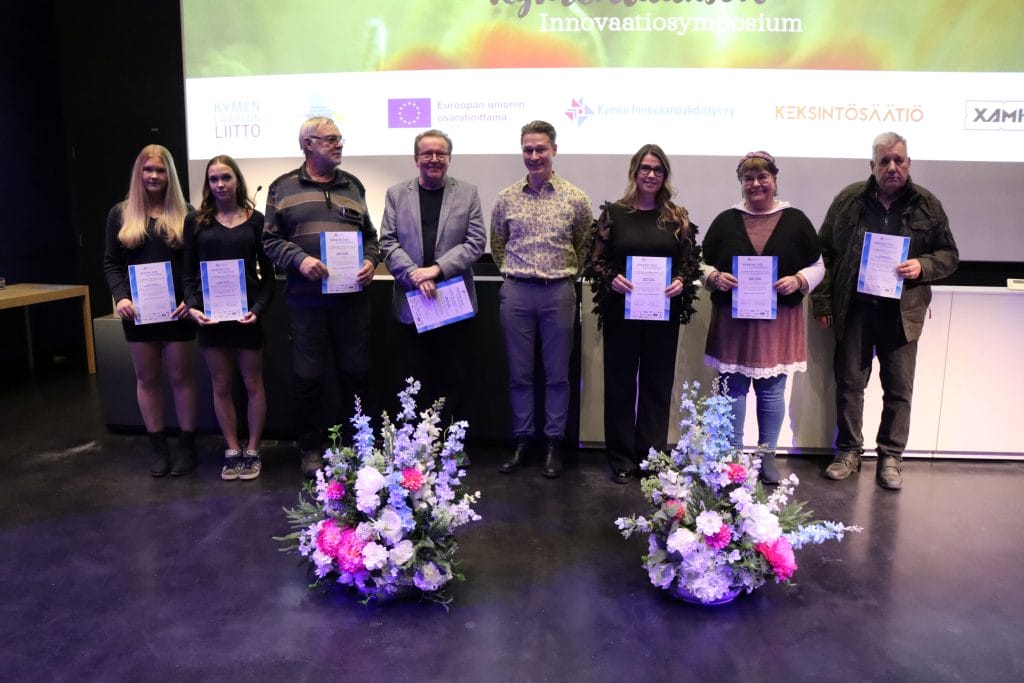 Ryhmä ihmisiä kunniakirjat käsissään.