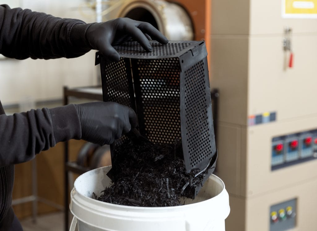 Pyrolysoitua hiiltä kaadetaan ämpäriin.