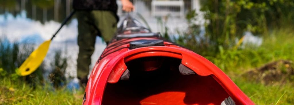 Ihminrn vetää kanoottia vesille.