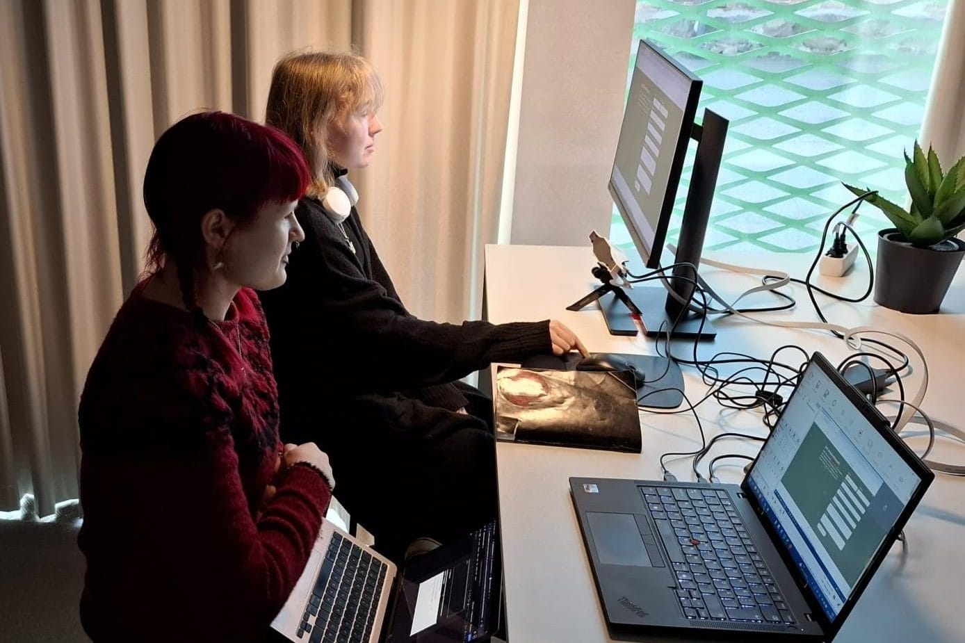 Verkkosivujen käytettävyystestaus. Kuvassa kaksi henkilöä, joista toinen on testihenkilö ja toinen testauksen vetäjä. Kannettavan tietokoneen näytöllä näkyy testihenkilön silmänliike hänen selatessaan verkkosivua.