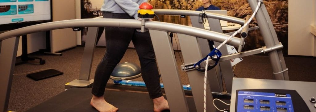 Ihminen kävelee kävelymatolla, vieressä mittalaitteita.