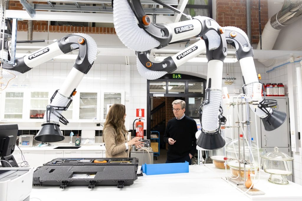 Nainen ja mies keskustelee laboratorioympärisössä.