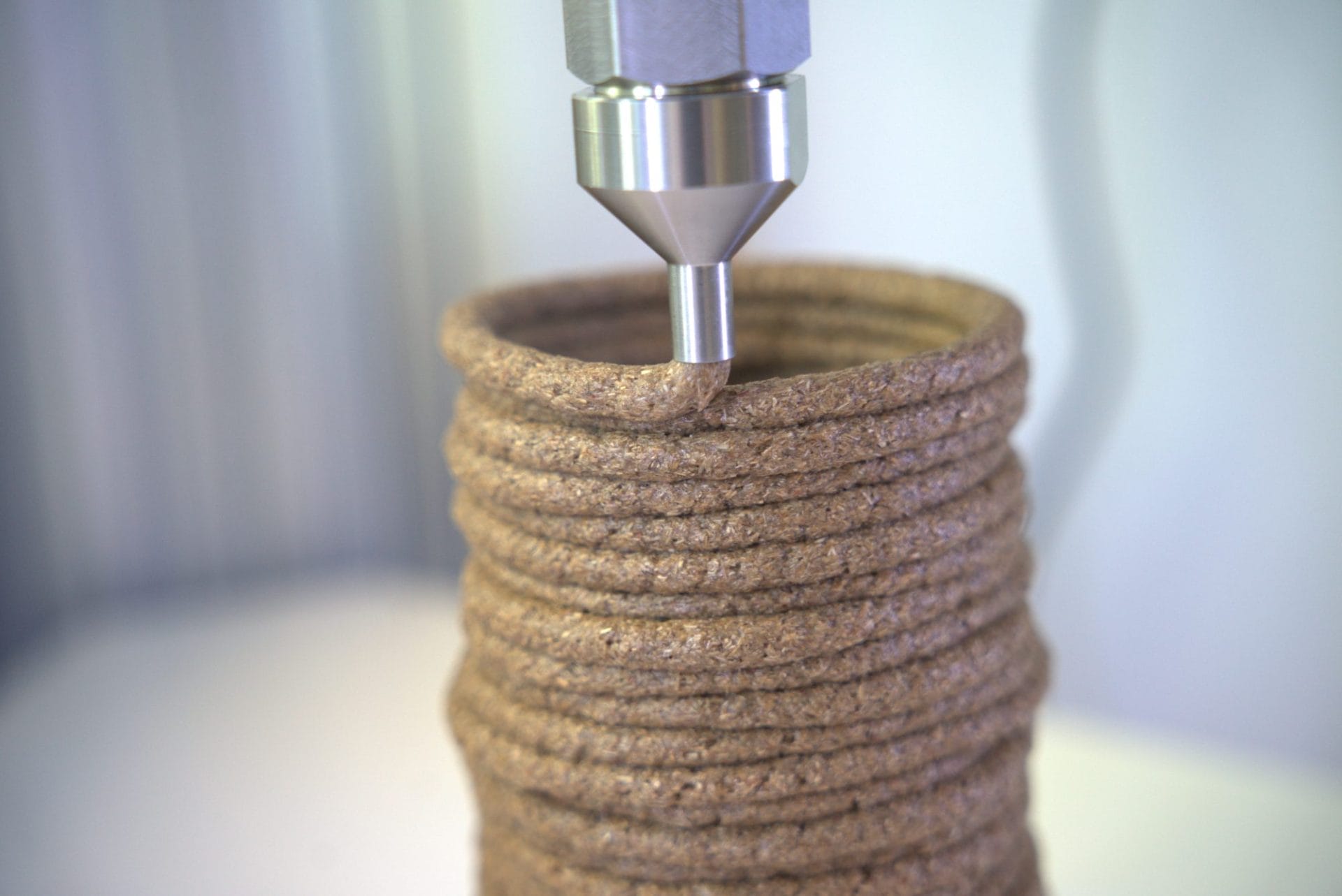 Biomateriaalimassa tulostuu suuttimesta sylinterin muotoiseksi kappaleeksi.