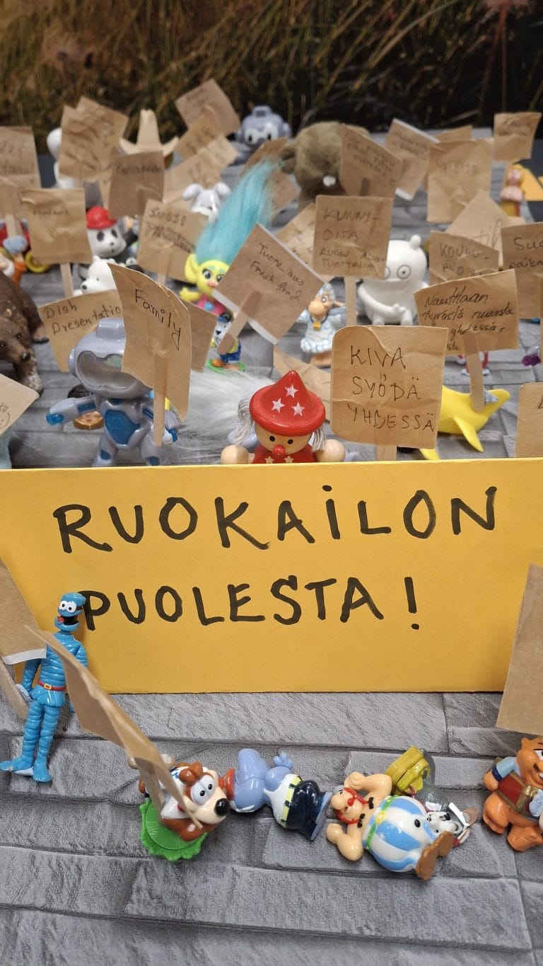 Hahmoja lappujen kanssa, joissa iskulauseita.