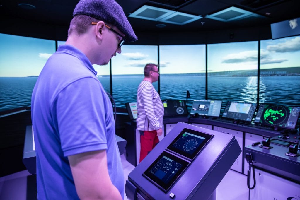 Kaksi henkilöä merenkulun simulaattorissa,