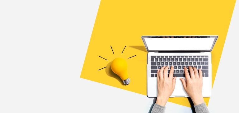 Person using a laptop computer and a light bulb