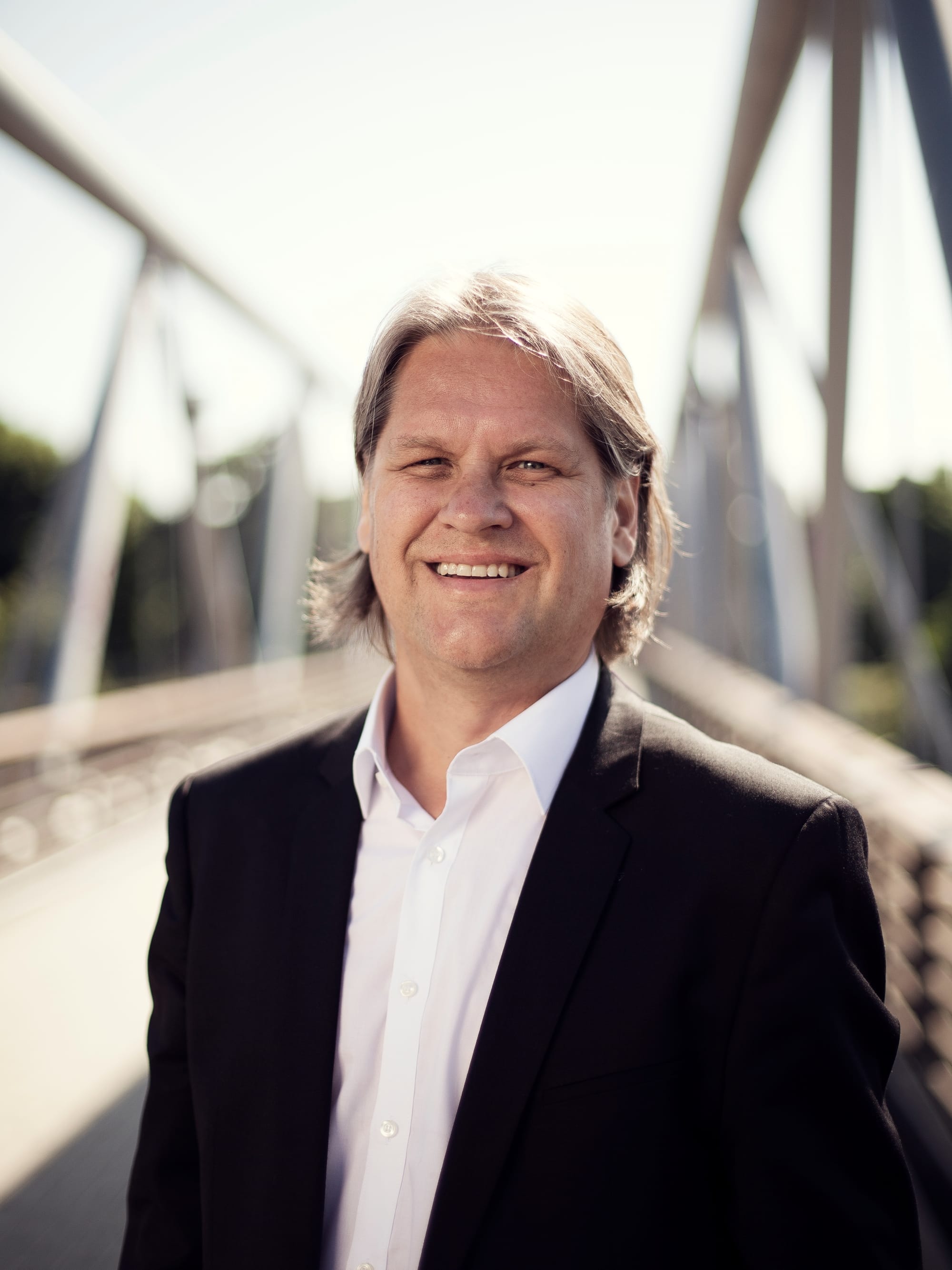 Hymyilevä henkilö ulkona.