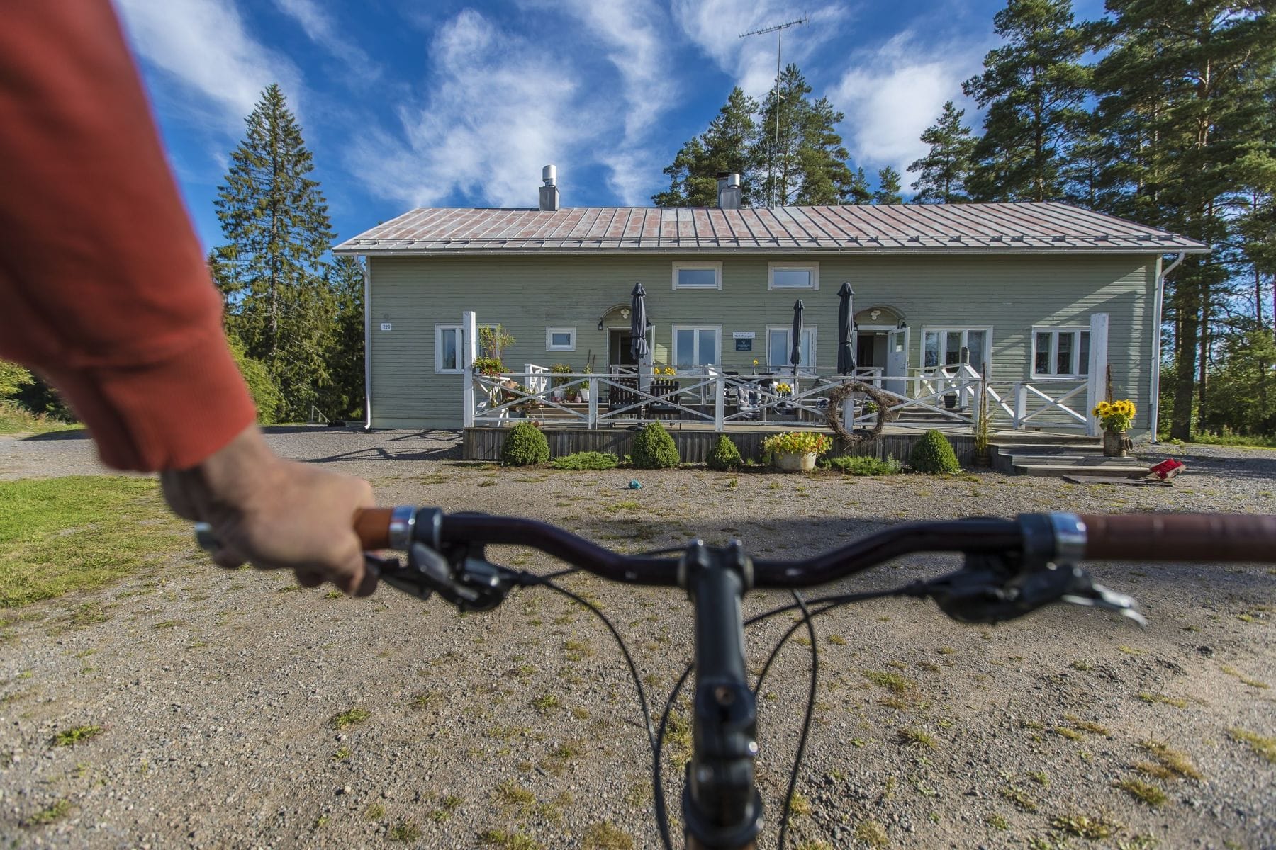 Pyöräilijä B&B Hiitolanjoen pihassa.