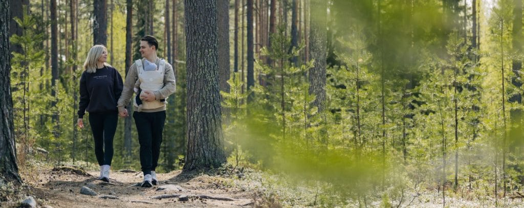 Perhe kävelyllä metsässä.