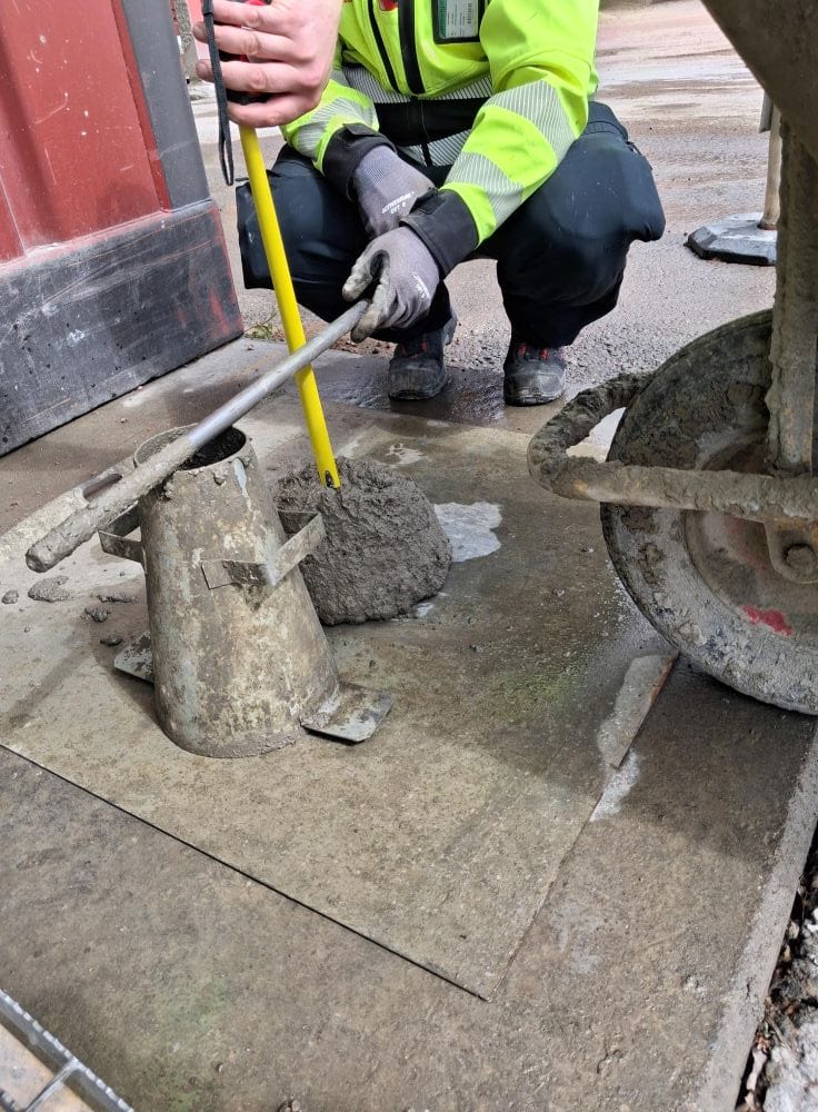Kuvassa mitataan tuoreen betonin painumaa.
