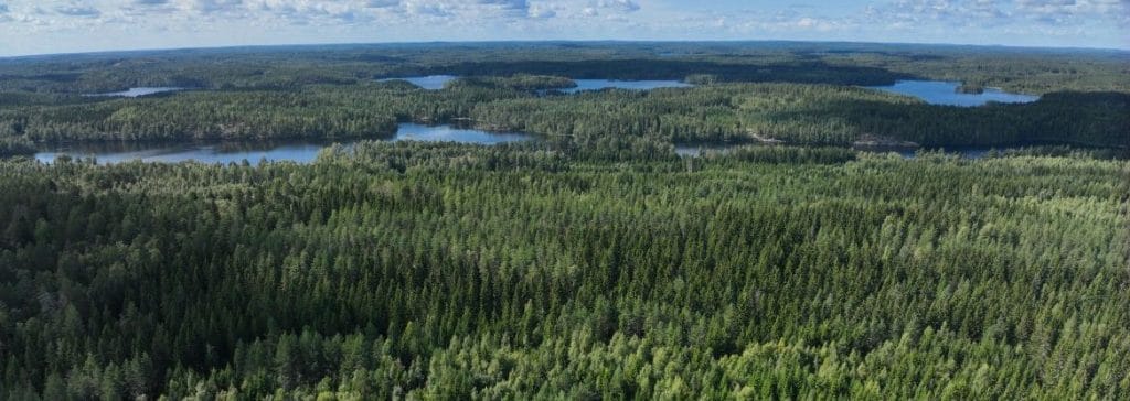 Ilmakuva metsäisestä maisemasta, jossa on myös järviä.