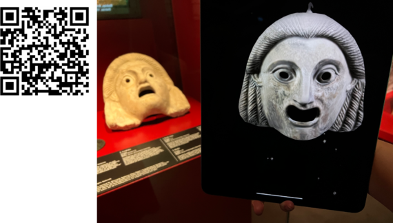 Museon vitriinissä oleva Pompejin naamio, kuvan etualalla sama naamio digitaalisena filtterinä tabletin ruudulla.