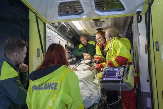 Ambulanssisimulaattori ja opiskelijoita harjoittelemassa