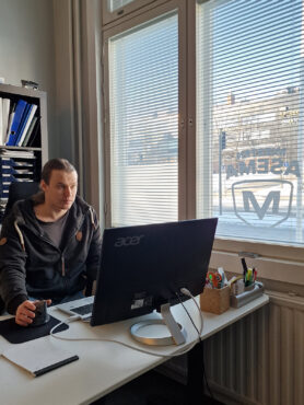 Ville Laitinen istuu tietokoneen äärellä.